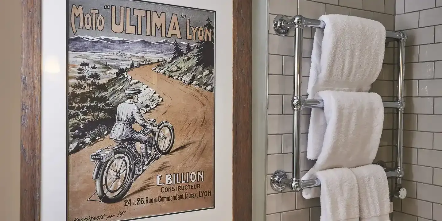 A bathroom featuring a towel rack and an image of a man riding a motorcycle.