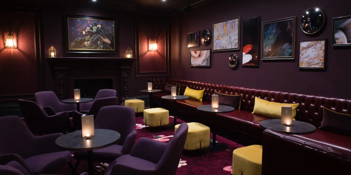 A room adorned with numerous purple chairs and tables.