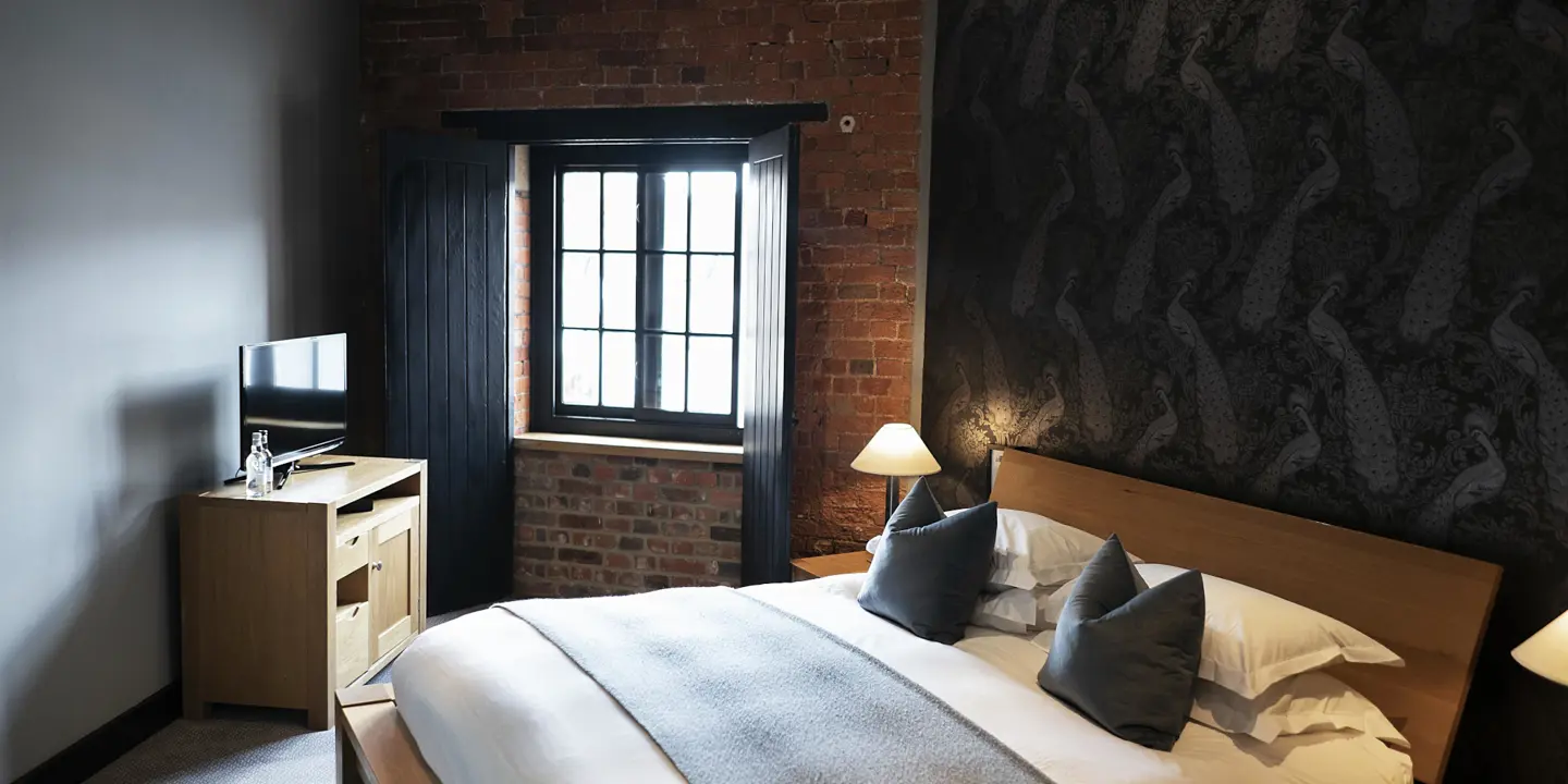 Bedroom featuring a brick wall and a bed.