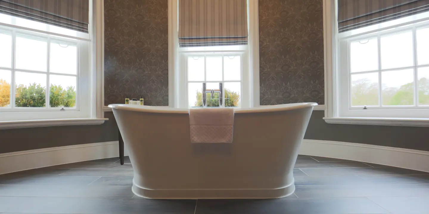 Bathroom with a bathtub positioned next to three windows.