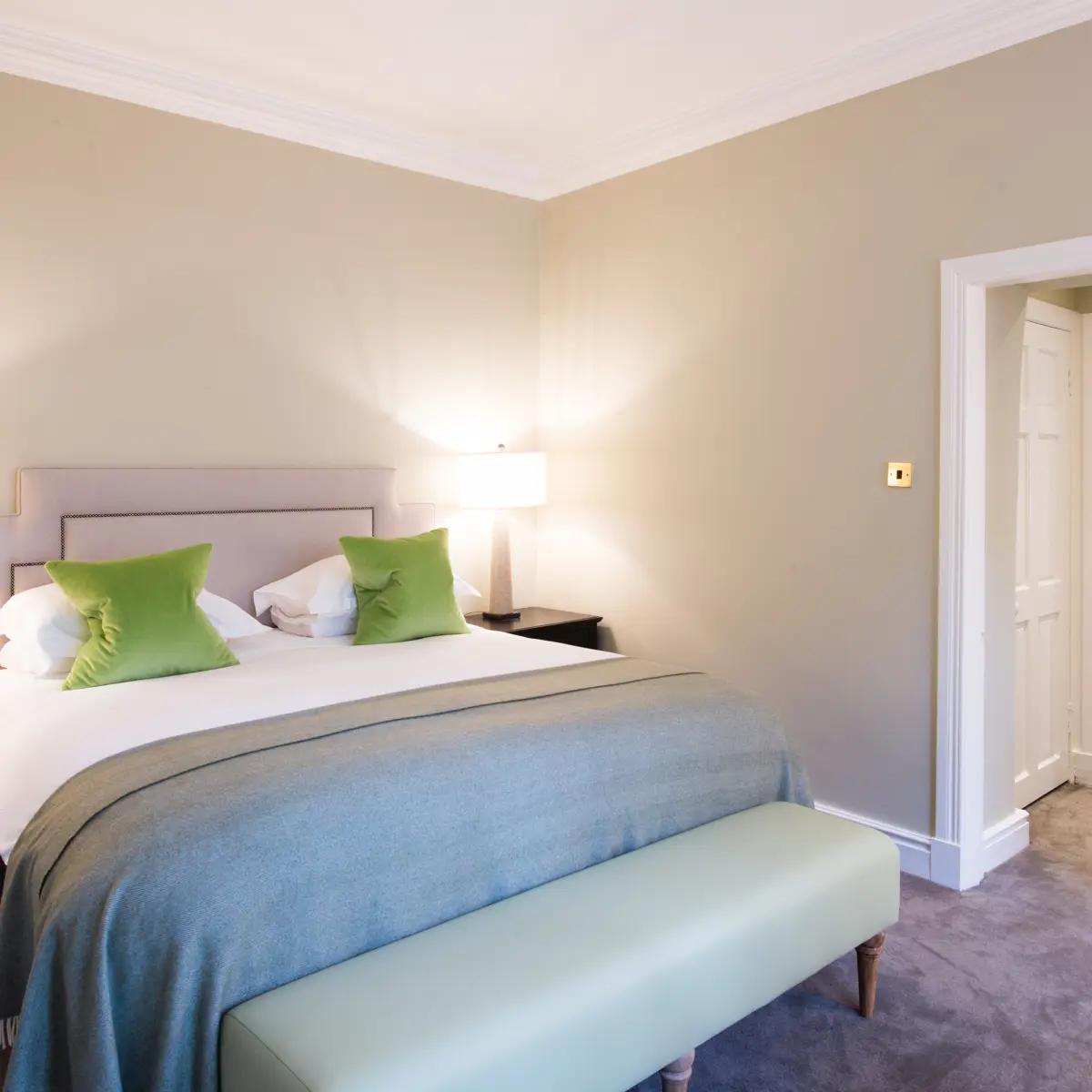 Bedroom featuring a comfortable bed and a stylish bench.