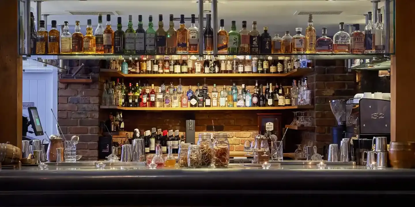 A well-stocked bar showcasing an array of liquor bottles neatly arranged on shelves.