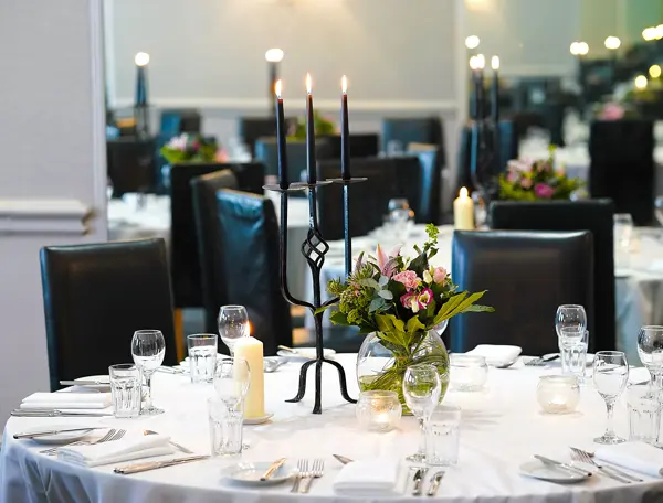 Table set for a formal dinner with candles and flowers.