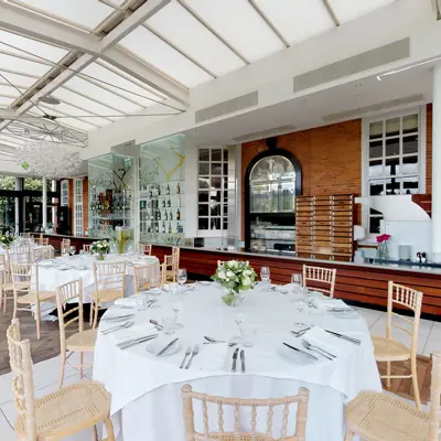 A dining room arranged with tables and chairs for a wedding.