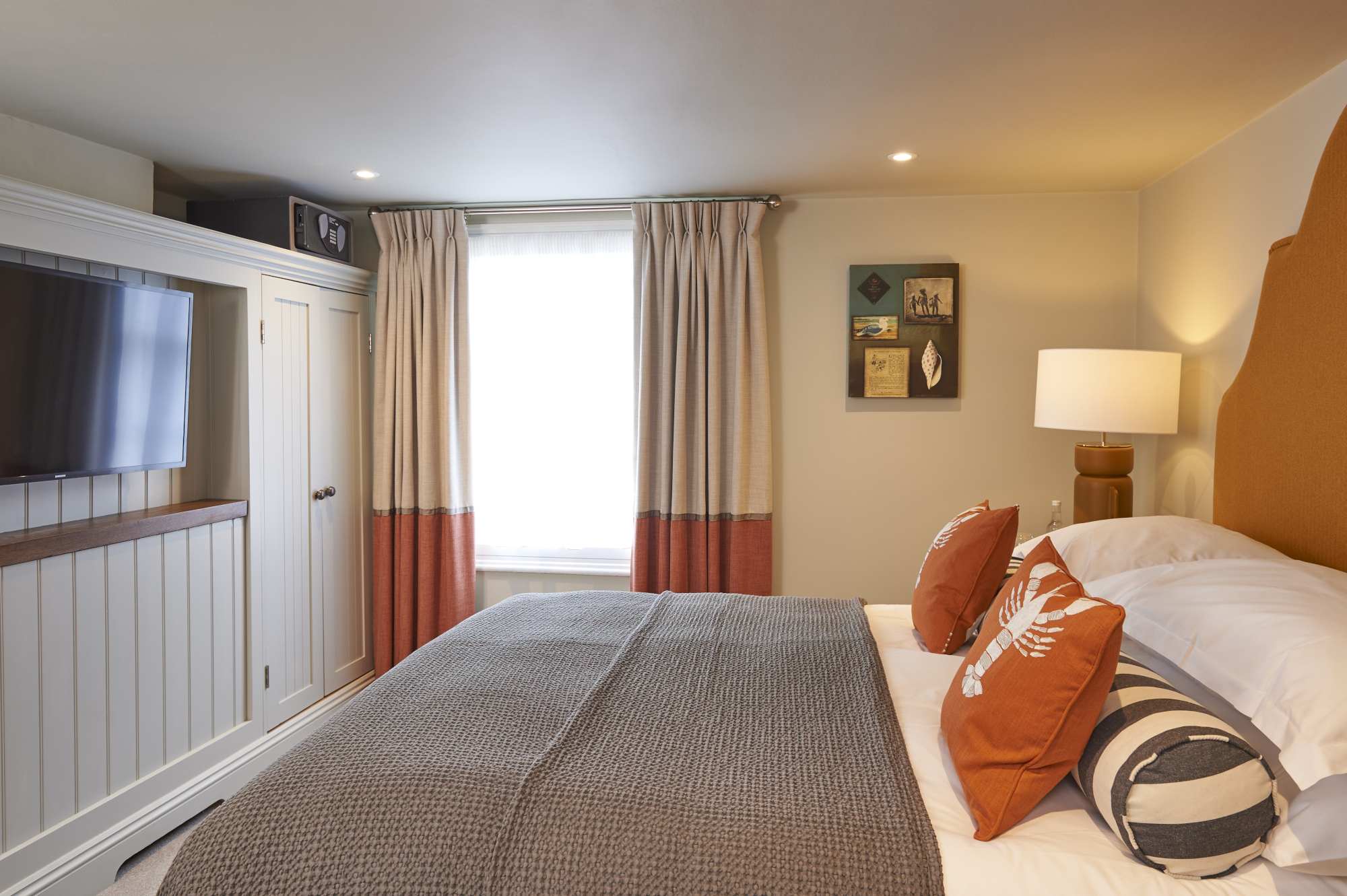 Spacious bedroom featuring a king-sized bed and a wall-mounted flat-screen television.