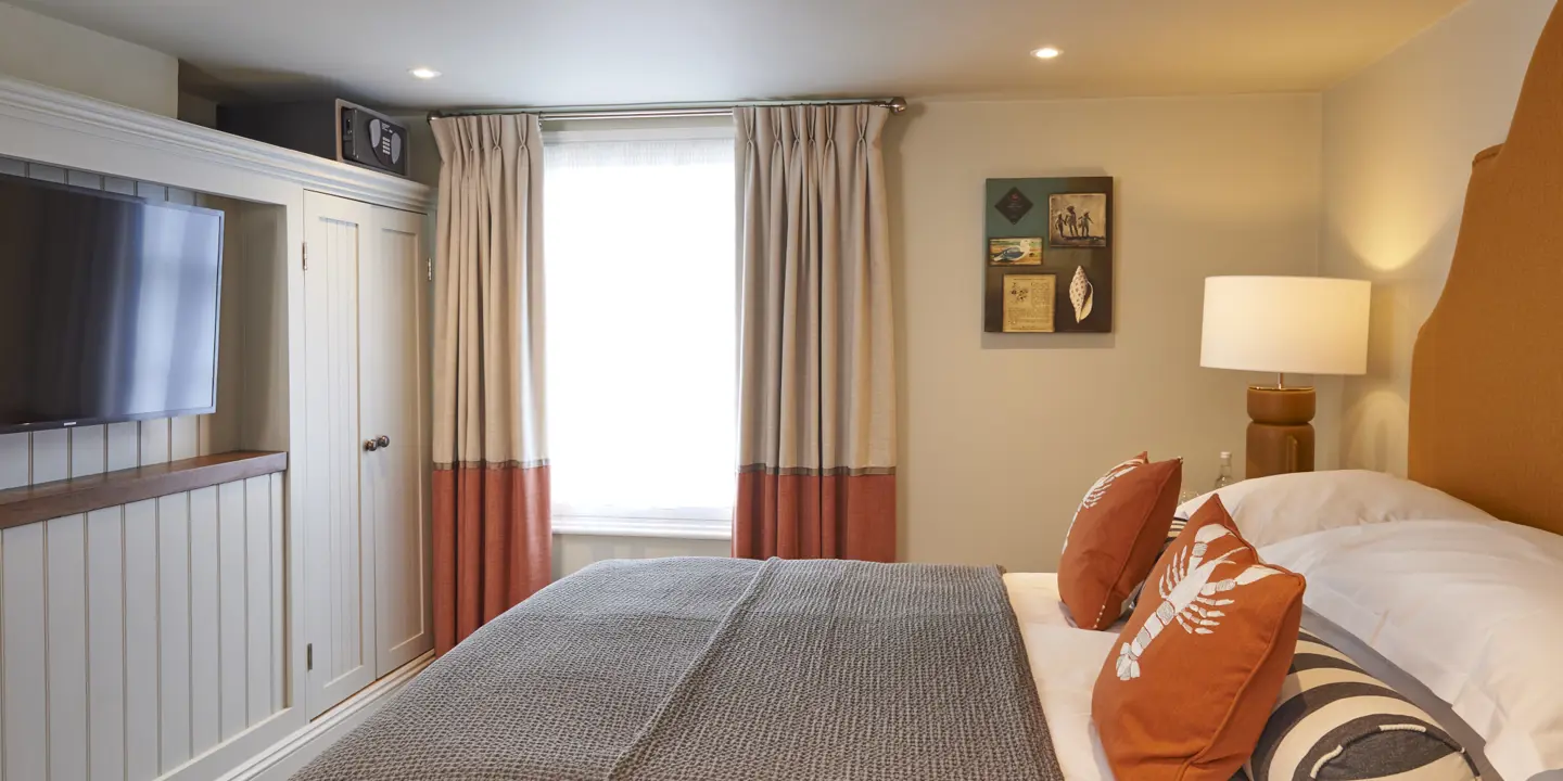 Spacious bedroom featuring a king-sized bed and a wall-mounted flat-screen television.