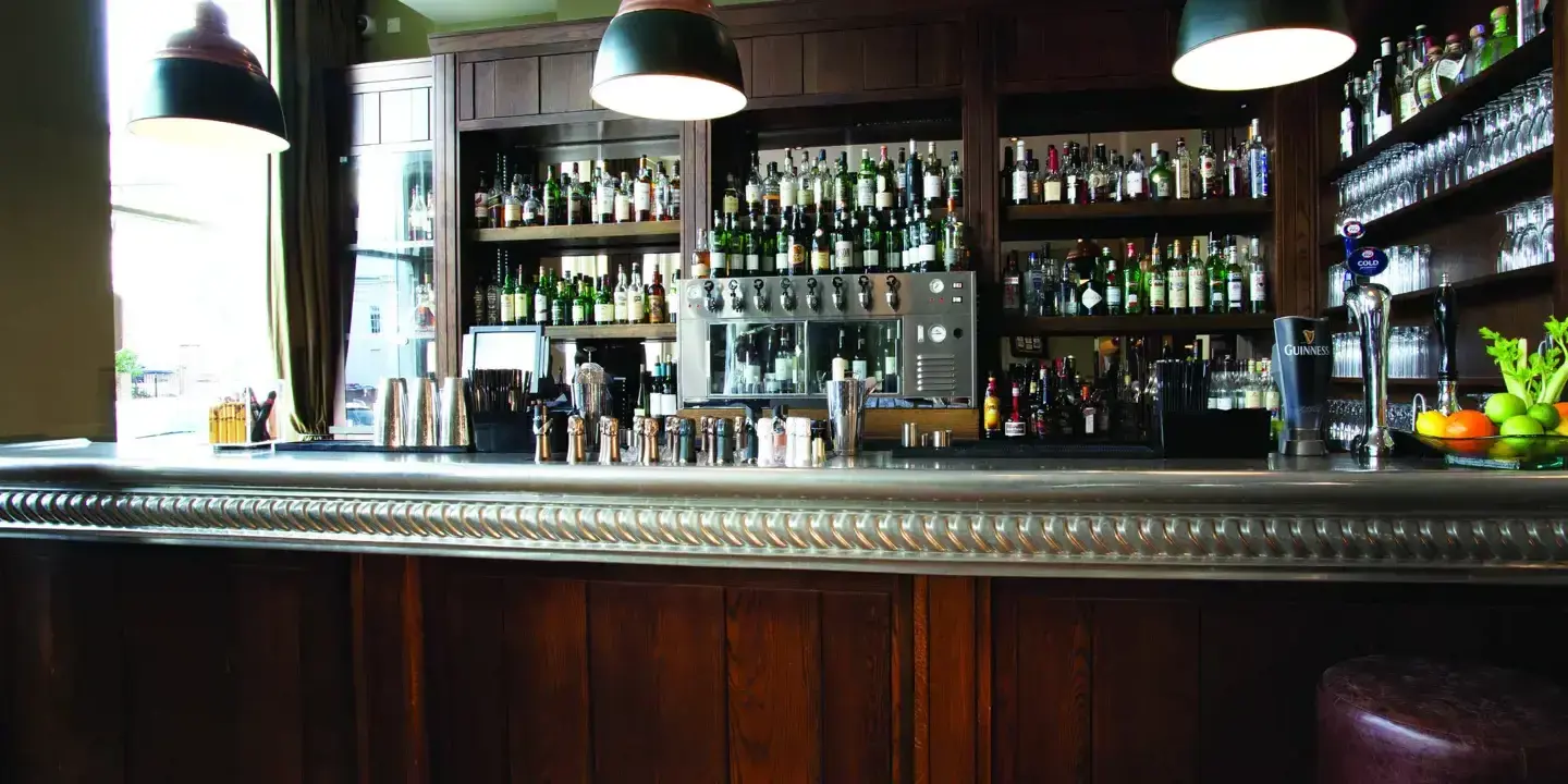 A bar counter displaying an assortment of bottles.