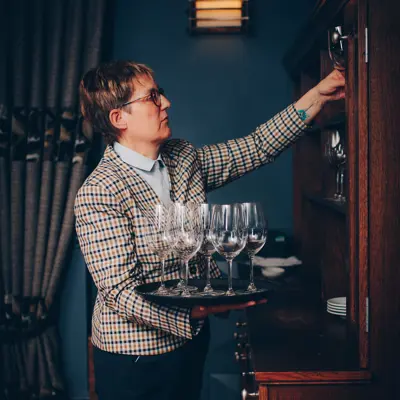 lady placing wine glasses on shelf