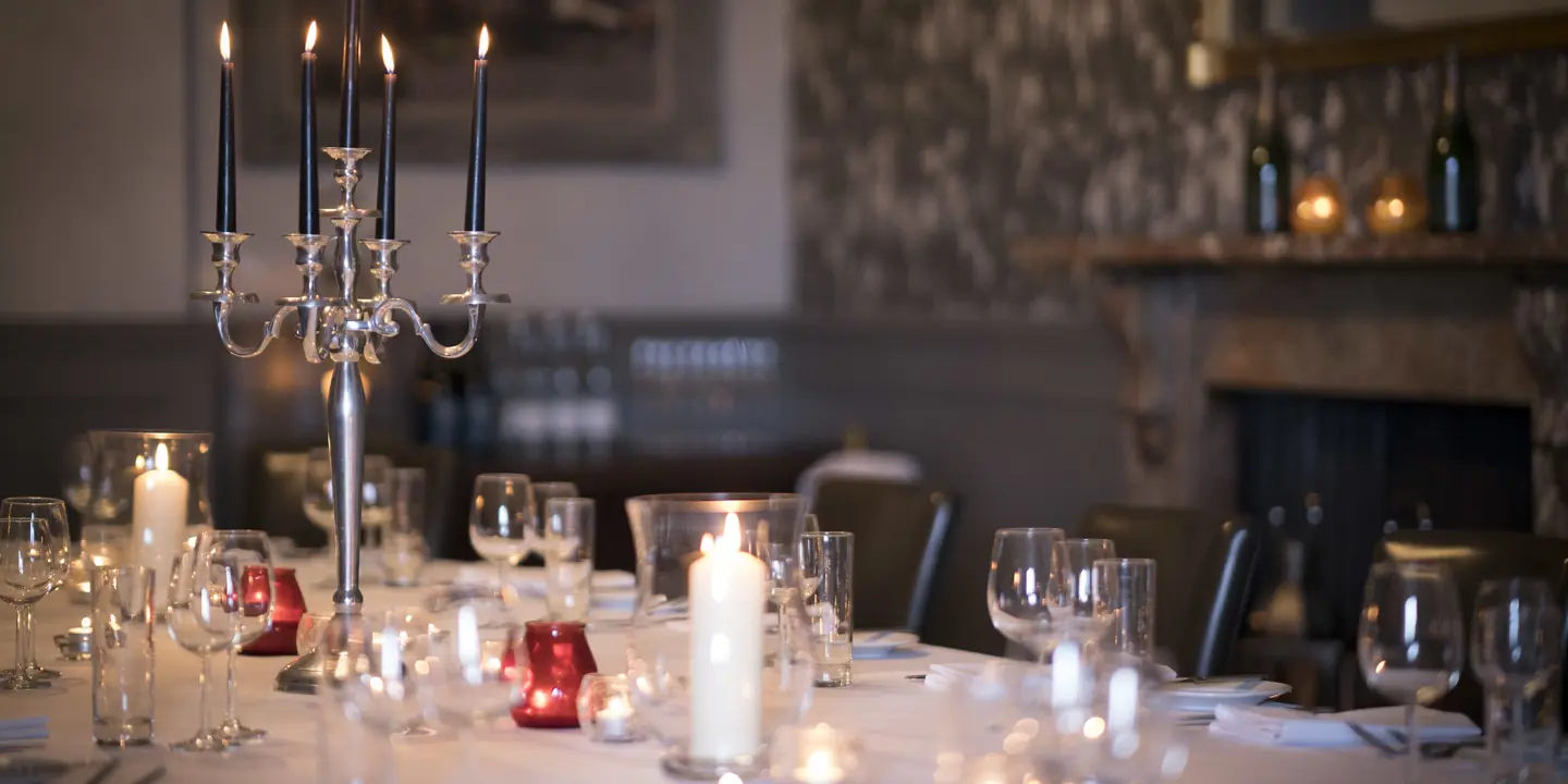 A beautifully arranged table adorned with elegant candles and wine glasses.