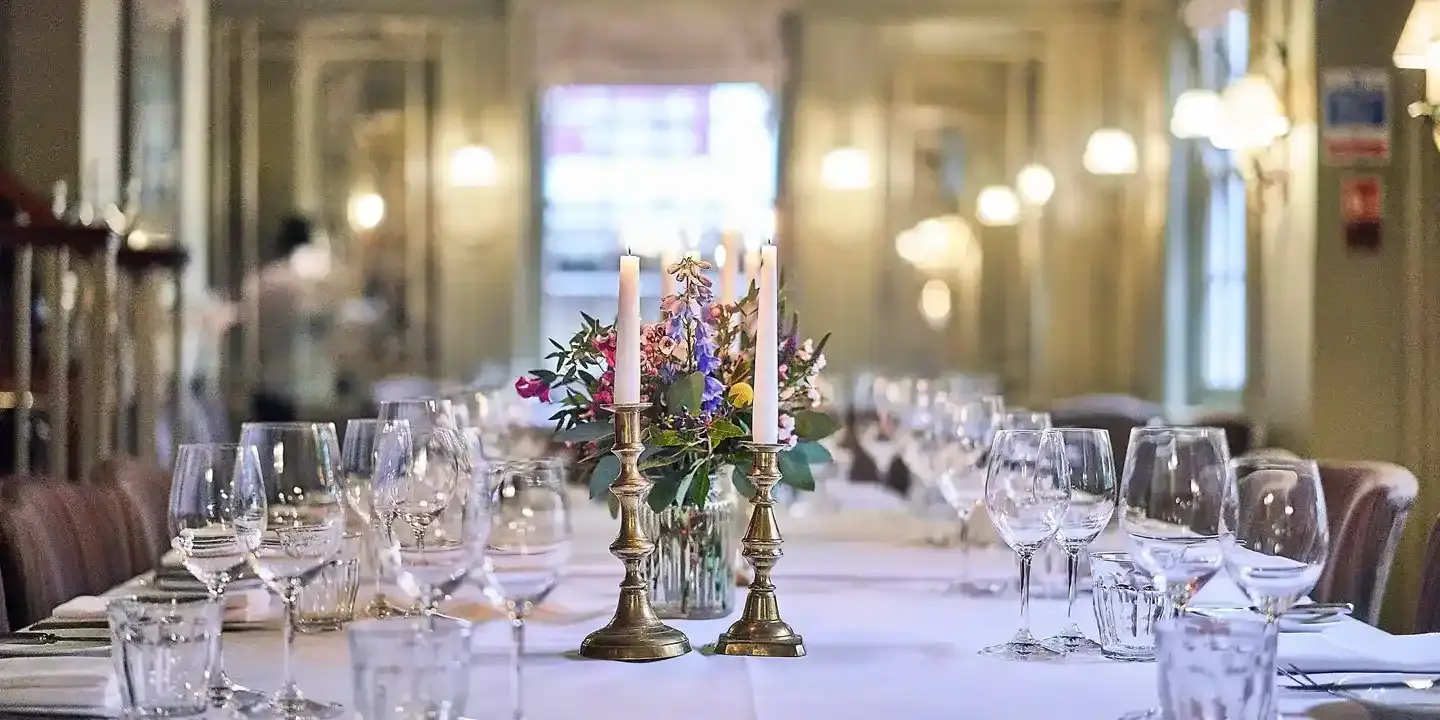 A beautifully arranged table adorned with elegant wine glasses and flickering candles.