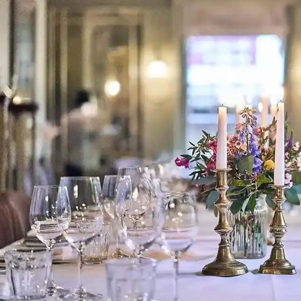 A beautifully arranged table adorned with elegant wine glasses and flickering candles.