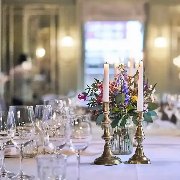 A beautifully arranged table adorned with elegant wine glasses and flickering candles.