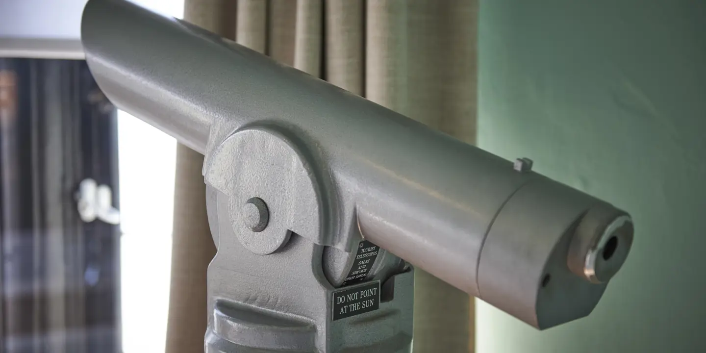 Close-up view of a telescope mounted on a pole.