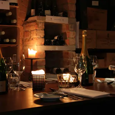 Wooden table adorned with wine glasses and bottles.