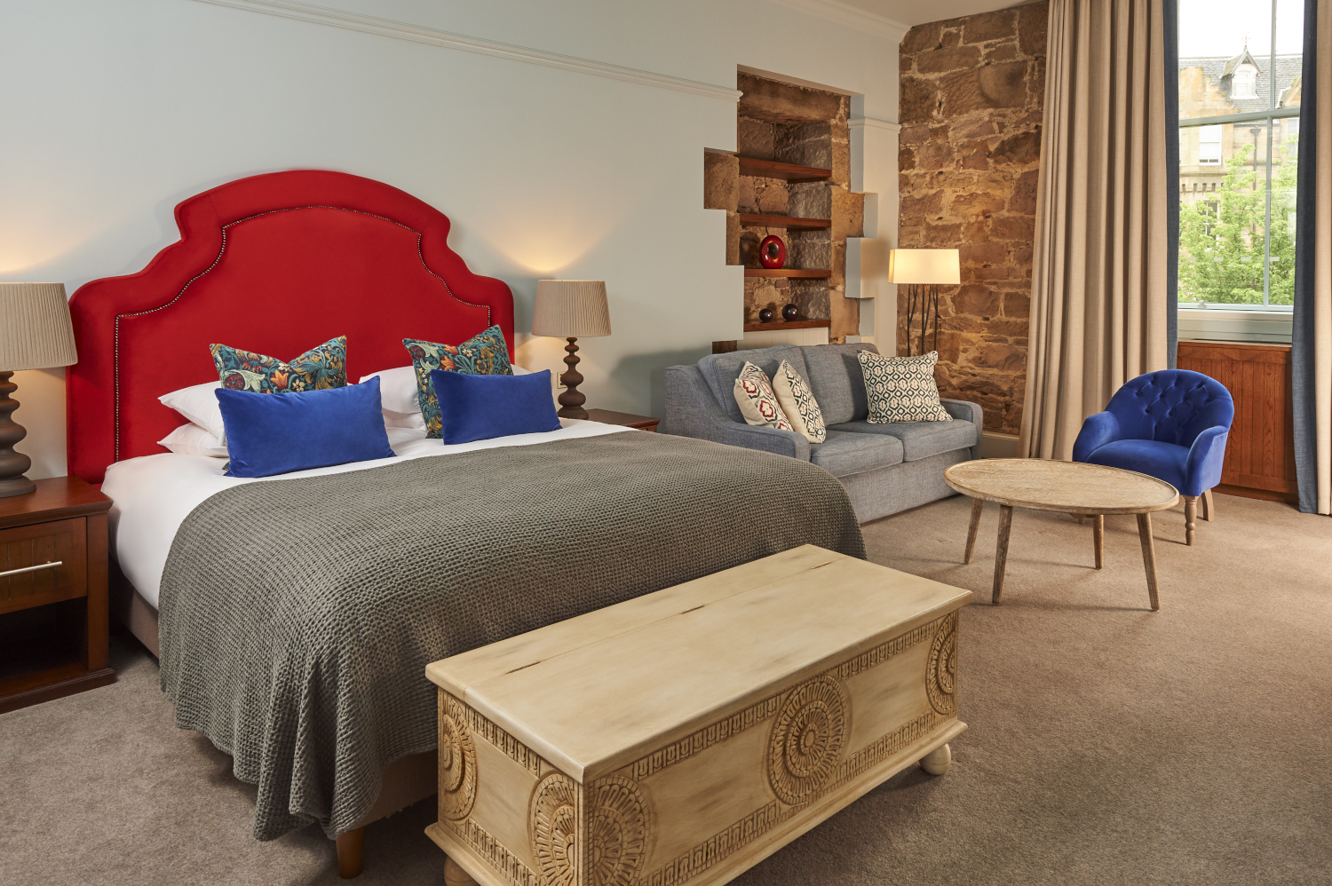 An elegantly furnished bedroom featuring a comfortable couch and a cozy bed.