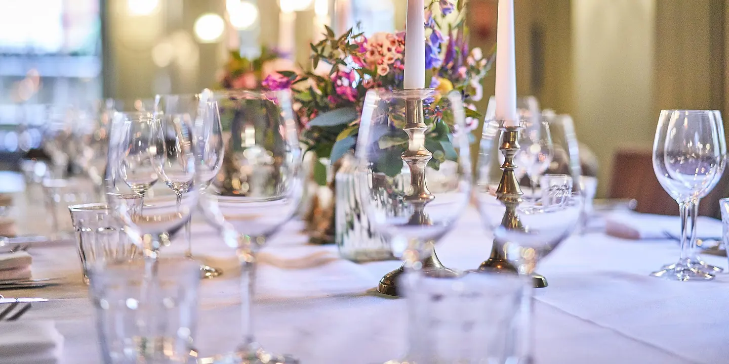 Table set for a formal dinner with candles and flowers.