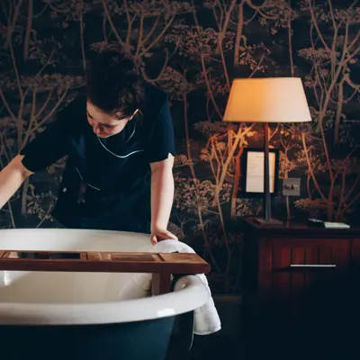 Housekeeper cleaning bathtub