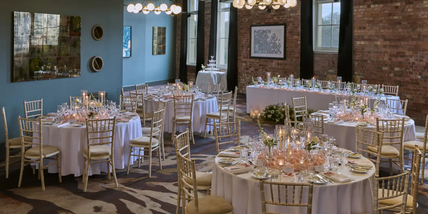 Table arranged with wine glasses, candles and bouquet of flowers.