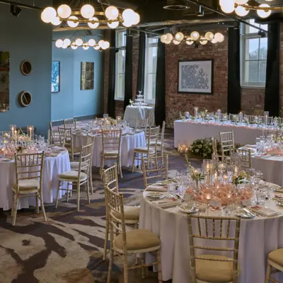 Table arranged with wine glasses, candles and bouquet of flowers.