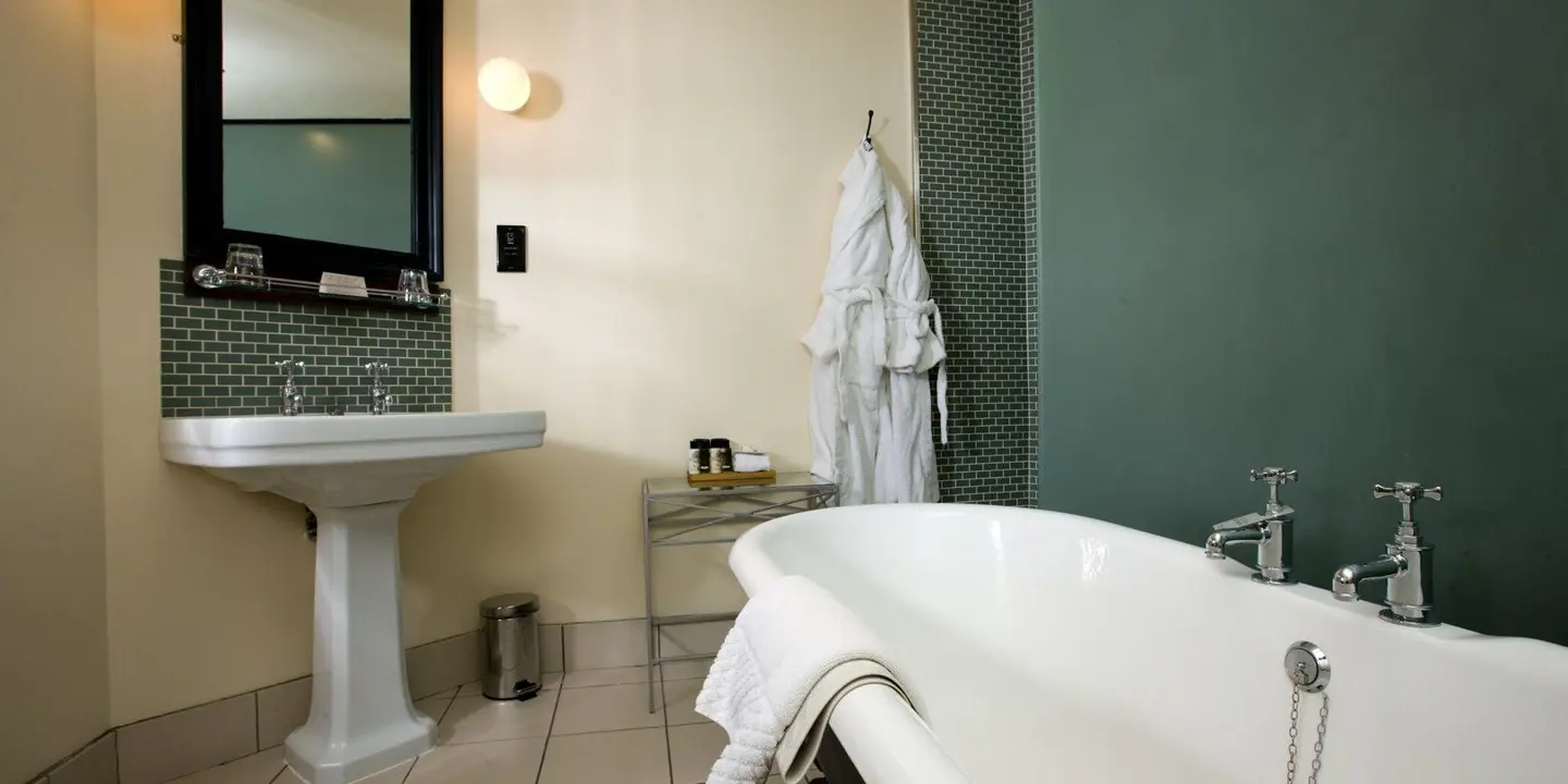 White bathtub positioned alongside a white sink.