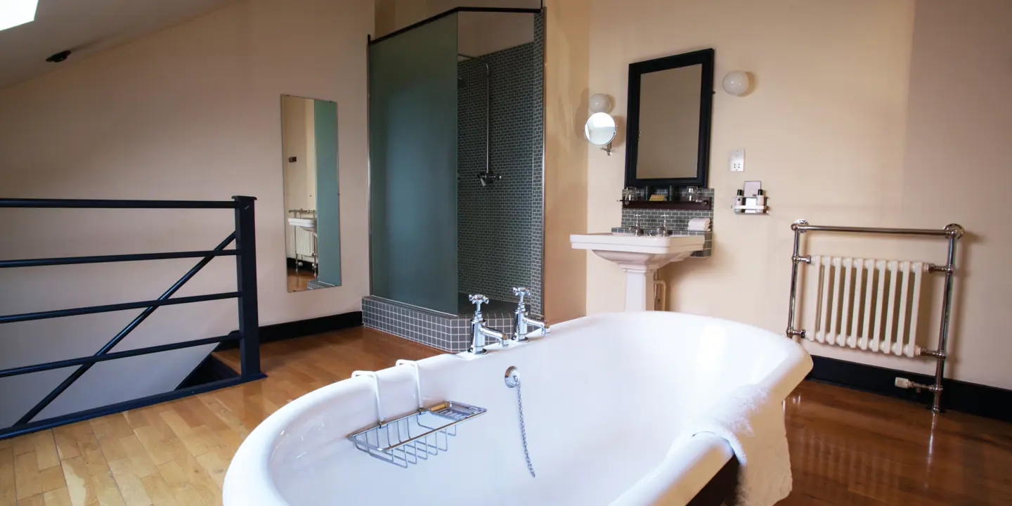 Bathroom featuring a large bathtub, sink, and mirror.