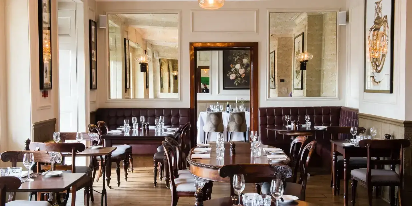 Dining room featuring tables, chairs, and mirrors.