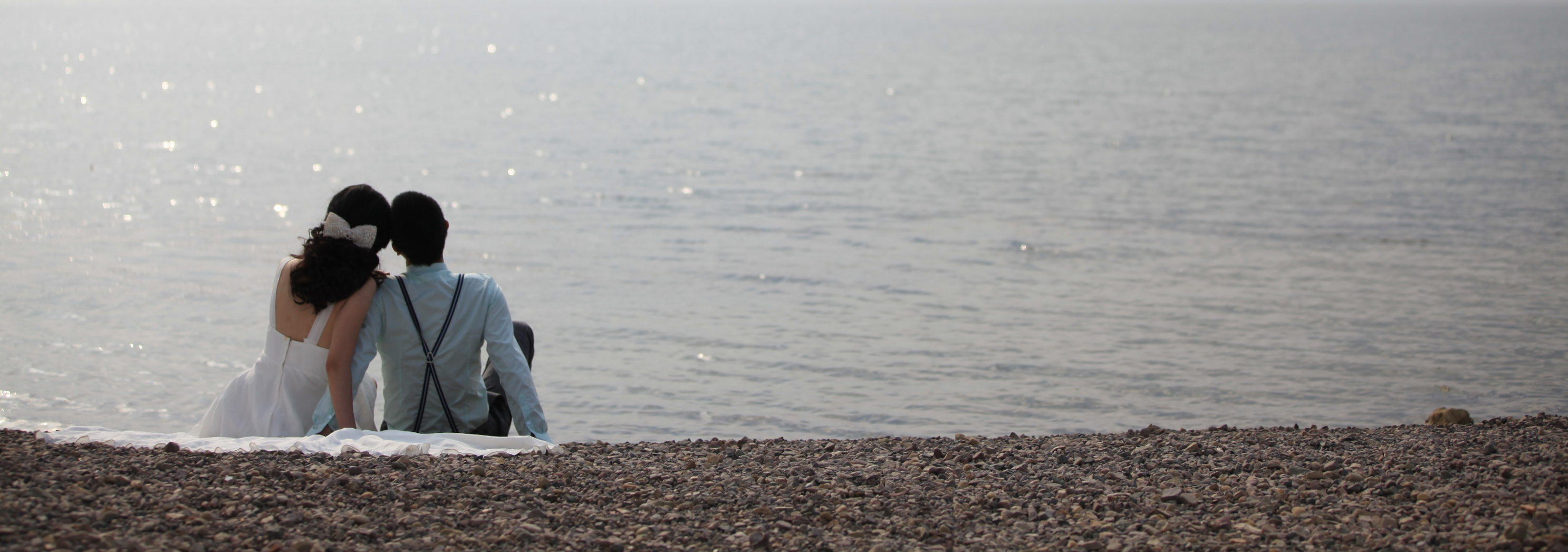 A couple enjoying a peaceful moment on the sandy beach.