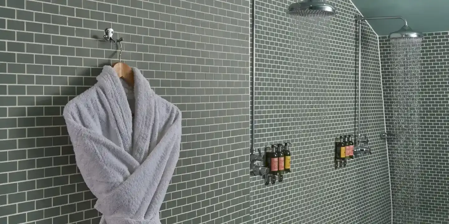 Bathroom wall with a hanging grey dressing gown.