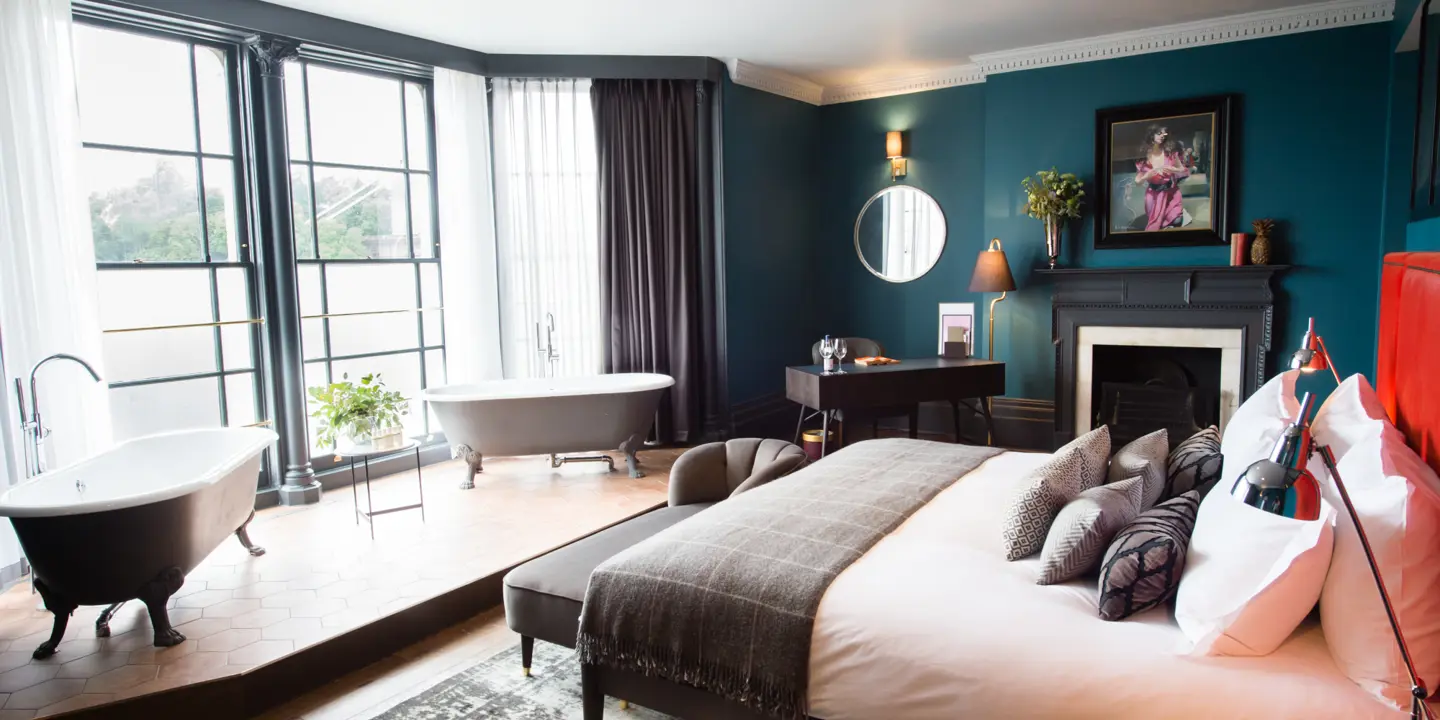 Spacious bedroom featuring a king-sized bed and an elegant fireplace.