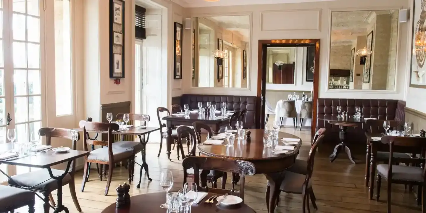 A restaurant featuring tables, chairs, and mirrors.