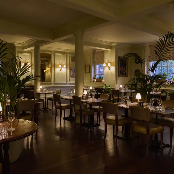 A lowly lit dining hall with a rustic wooden theme