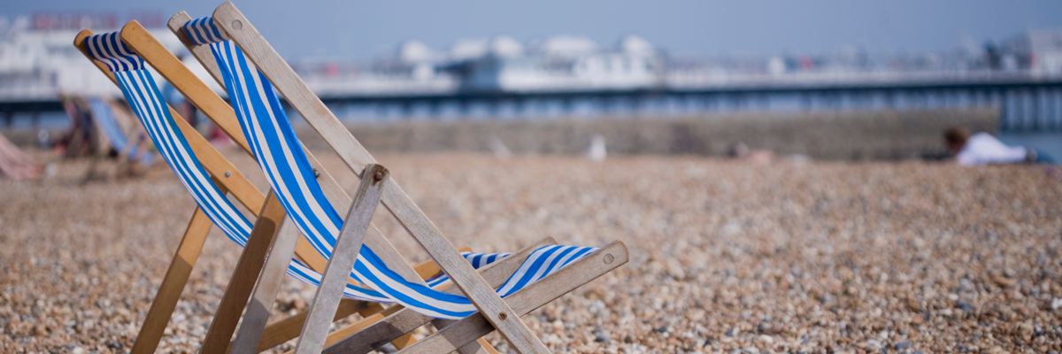 A beach chair resting on a rocky shoreline.