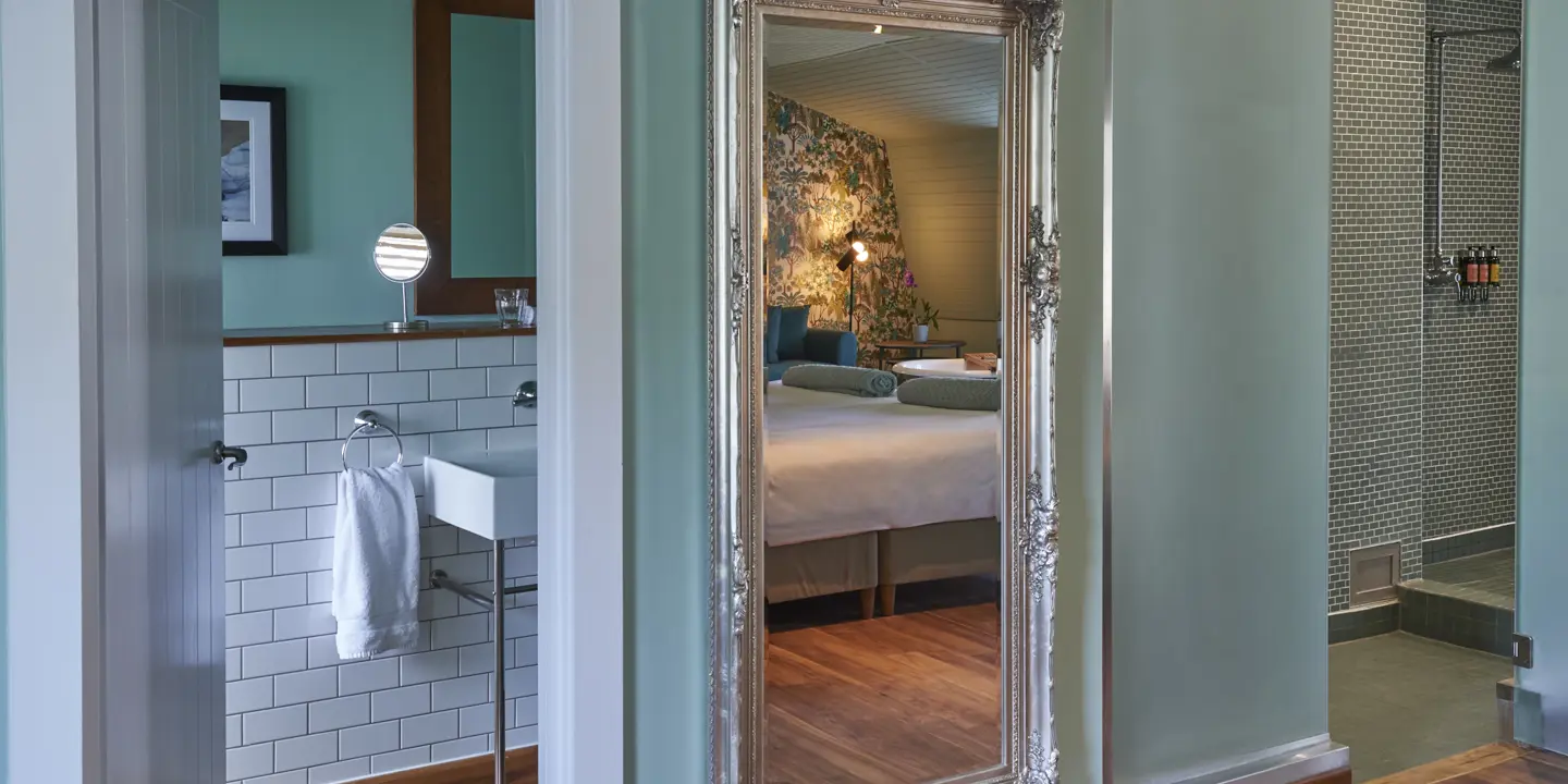 Bedroom featuring a spacious wall-mounted mirror.