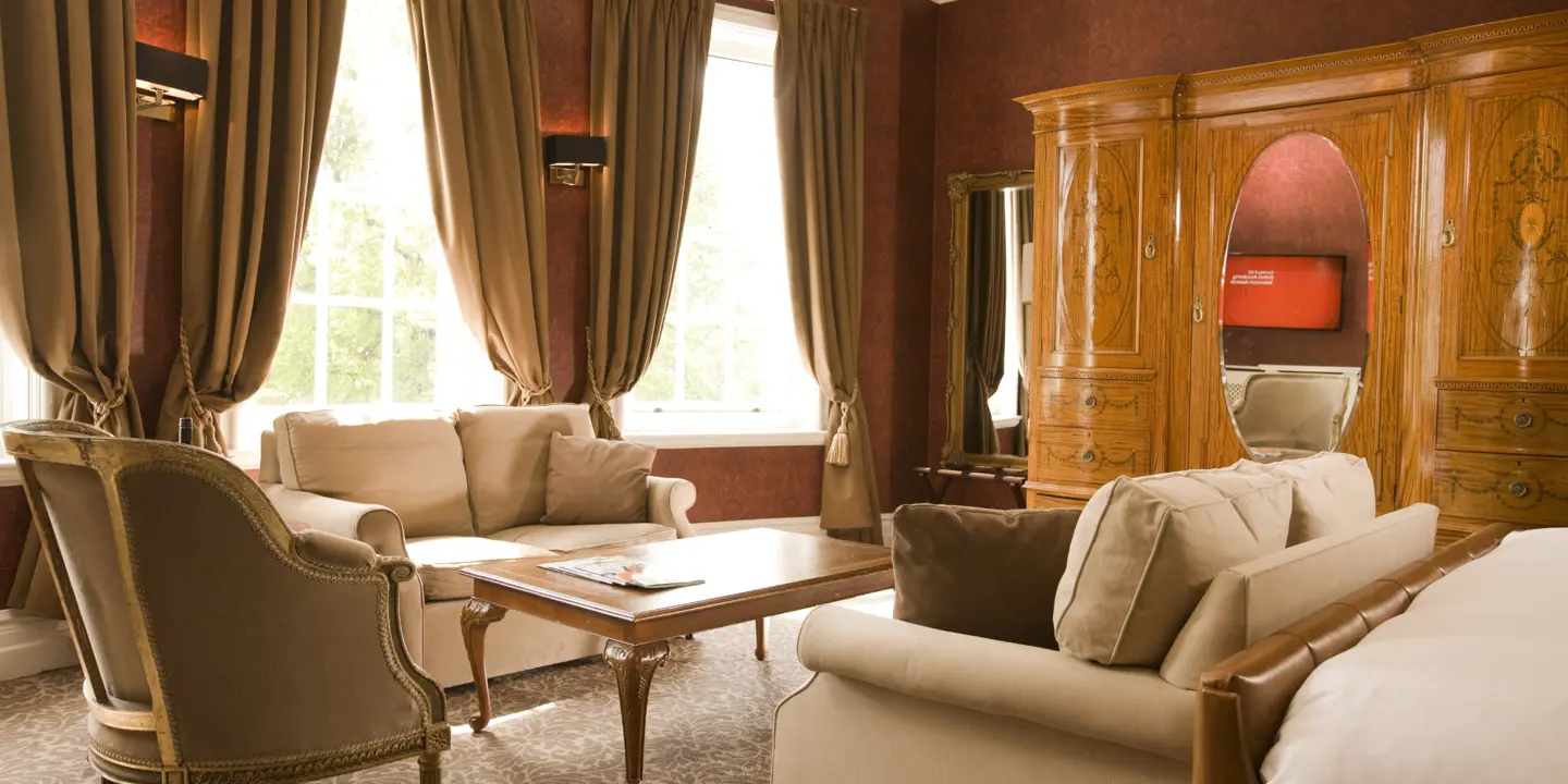 A well-furnished living room with ample seating and a spacious window.