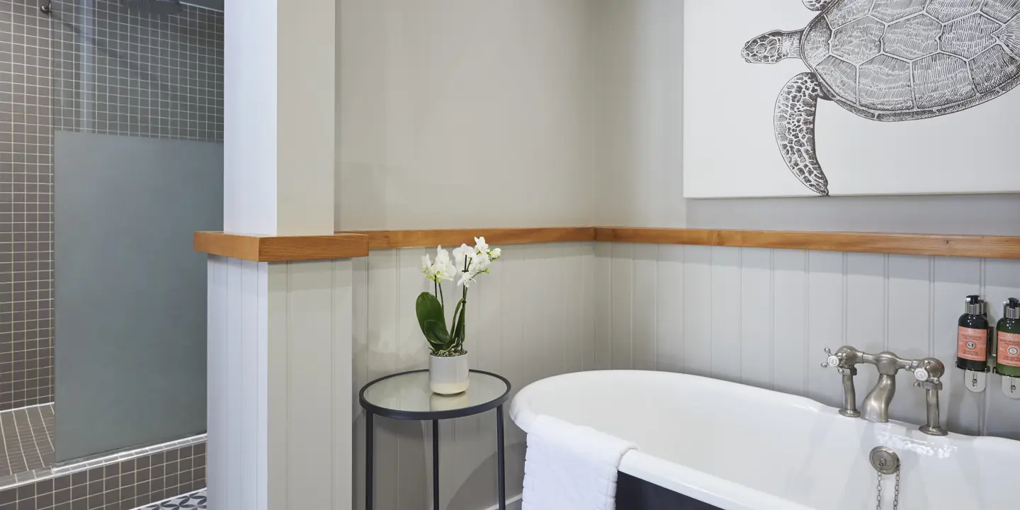 A bathroom featuring a bathtub, sink, and an elegant painting.
