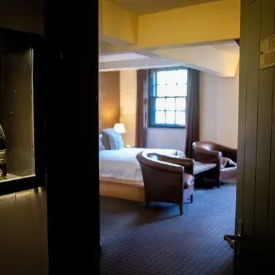 An elegantly furnished hotel room featuring a comfortable bed and a stylish chair.