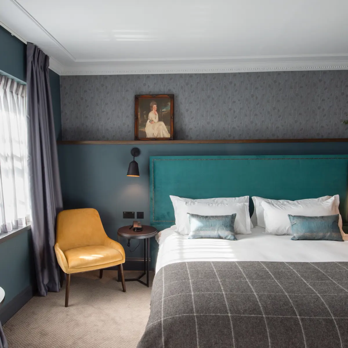 Bedroom featuring a blue headboard and a yellow chair.