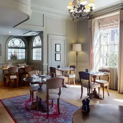 A dining room featuring an elegant chandelier hanging from the ceiling.