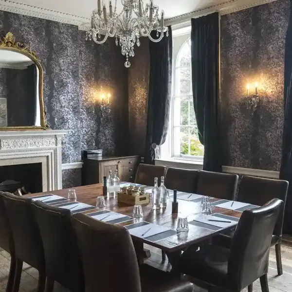 A dark themed Meeting room with an assorted table and chairs