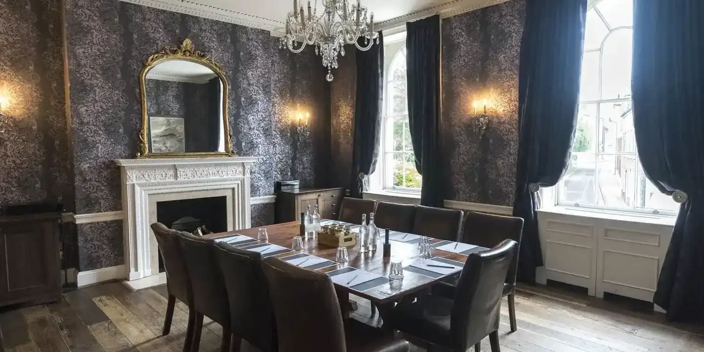 A dark themed Meeting room with an assorted table and chairs