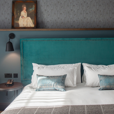 Blue headboard and pillows on a bed.