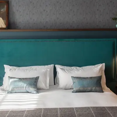 Blue headboard and pillows on a bed.