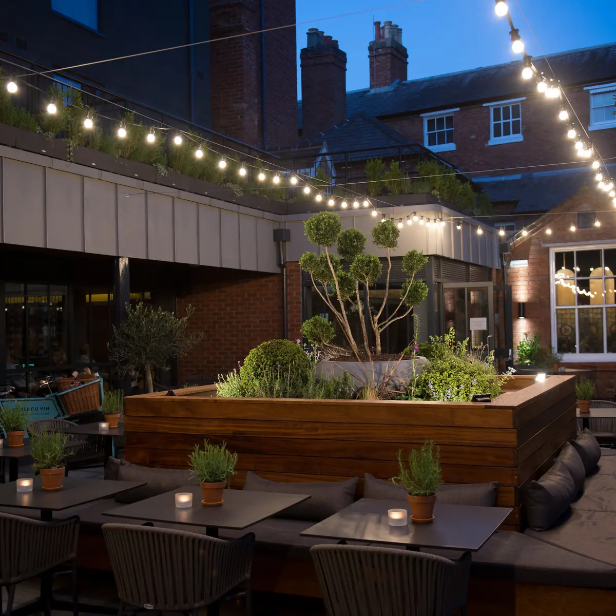 Patio area featuring tables, chairs, and charming fairy lights.