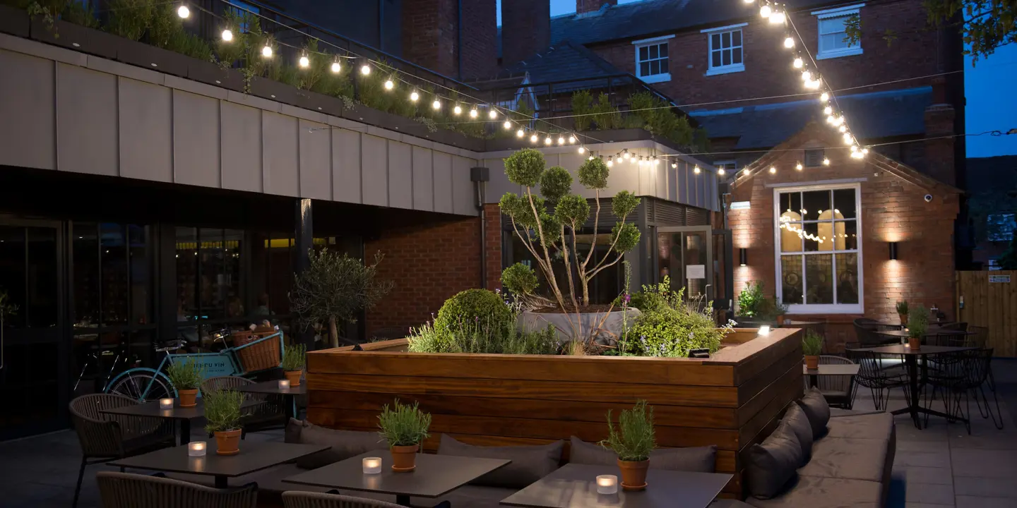 Patio area featuring tables, chairs, and charming fairy lights.