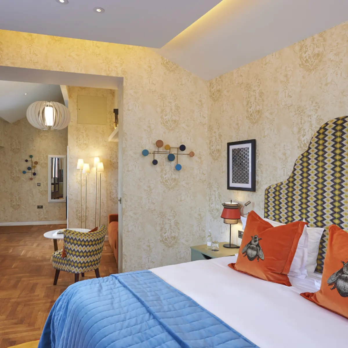 An elegantly furnished hotel room featuring a comfortable bed, sofa and a functional desk.