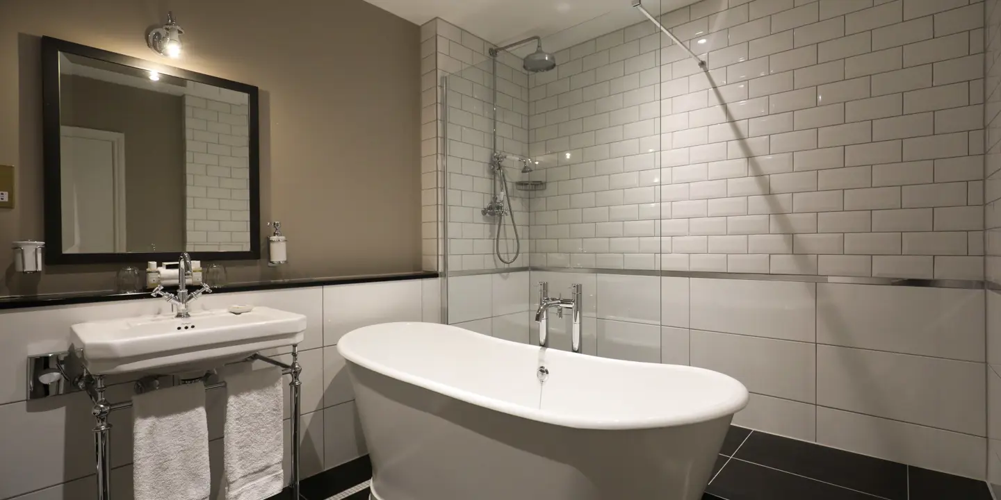 White bathtub positioned alongside a sink beneath a mirror.