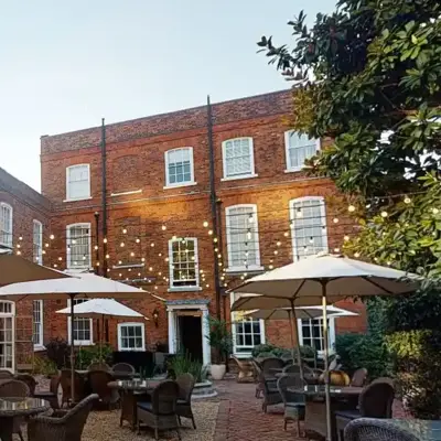 A courtyard featuring tables, chairs, and umbrellas.