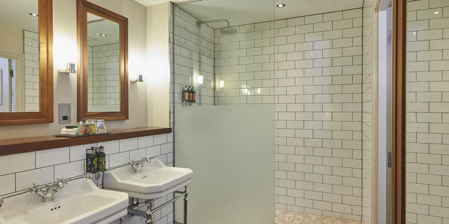 Bathroom featuring two sinks and a shower.