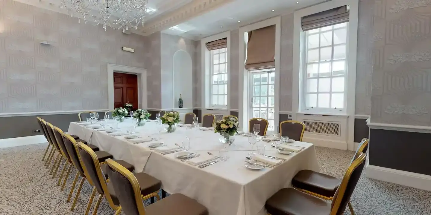 A beautifully arranged long white dining table with elegant place settings.