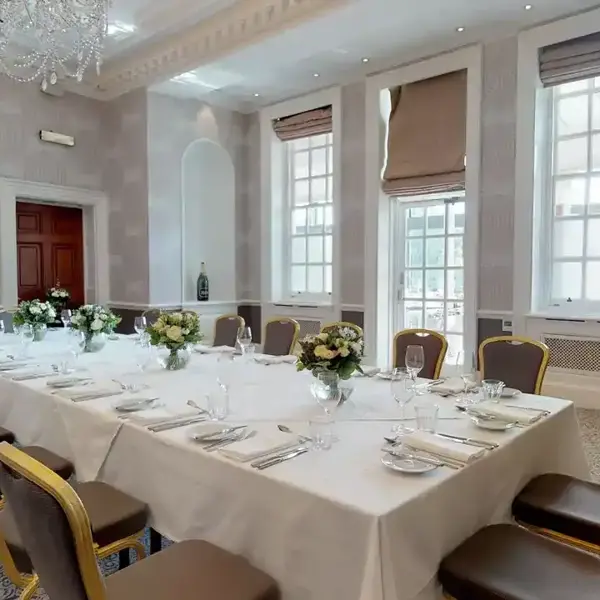 A beautifully arranged long white dining table with elegant place settings.